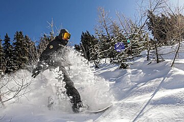 snowboarding in powder in Verbier on a sunny day