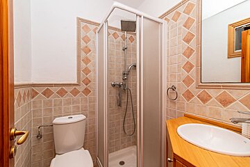 A bathroom with a toilet a sink and a shower