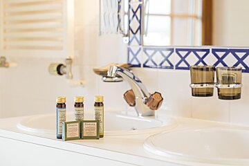 A bathroom sink with bottles of shampoo and soap on it