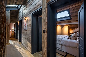 A hallway leading to a bedroom with a bed