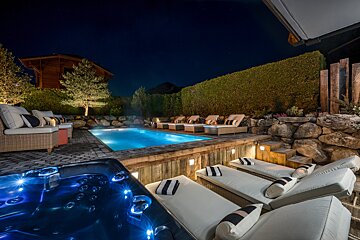 A swimming pool with a hot tub in the middle of it