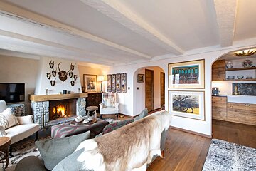 A living room with a fireplace and paintings on the wall