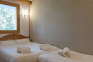 A bedroom with two beds and a window