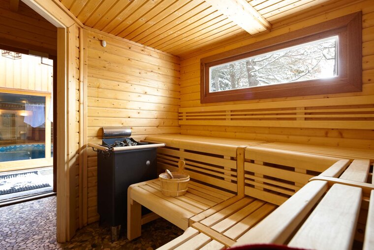 A wooden sauna with a bucket on the bench