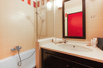 A bathroom with a sink and a red mirror