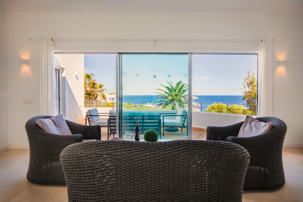 A living room with wicker furniture and a view of the ocean