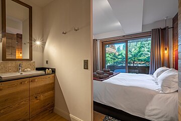 A bathroom next to a bedroom with a sliding glass door
