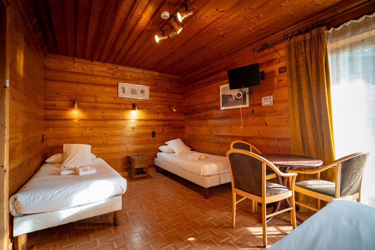 A wooden room with two beds and a table