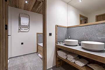 A bathroom with two sinks and a towel rack