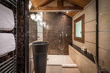 A bathroom with a sink and a walk in shower