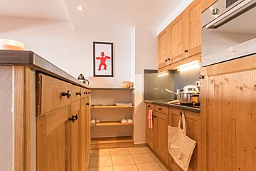 A kitchen with wooden cabinets and a picture of a man on the wall