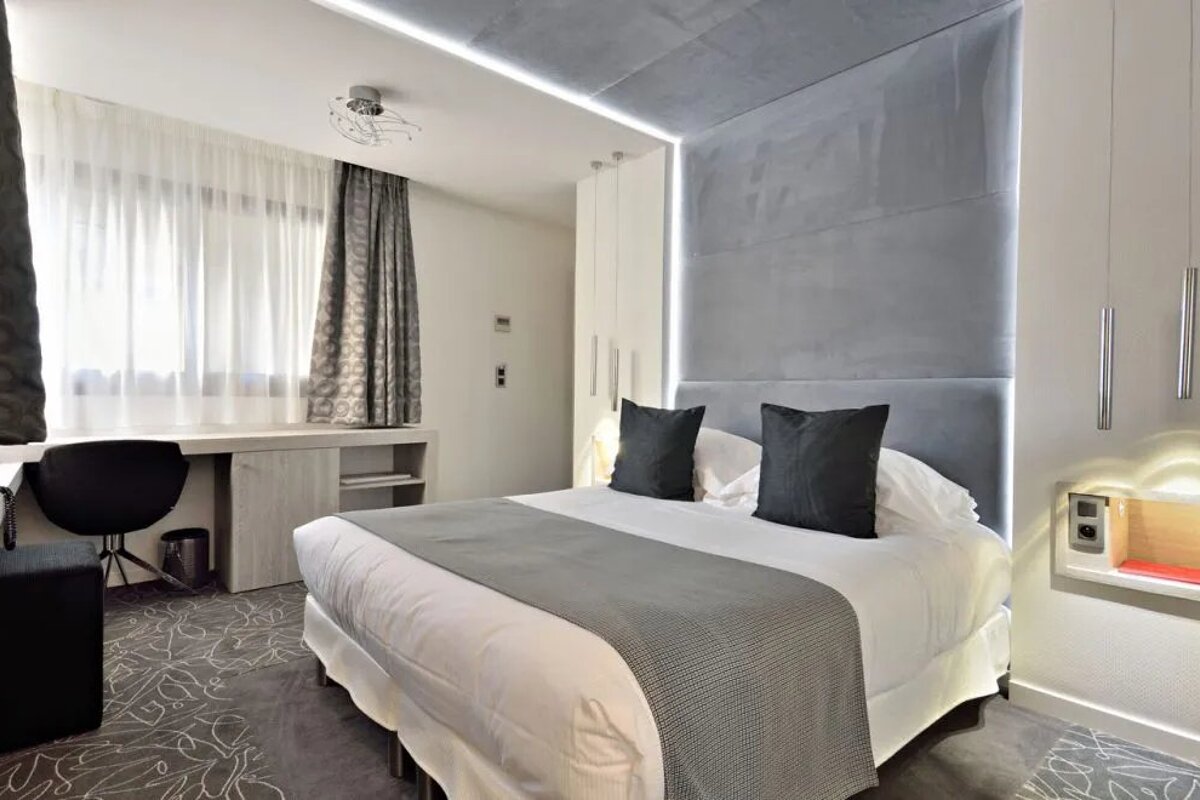 A hotel room with a bed and a desk