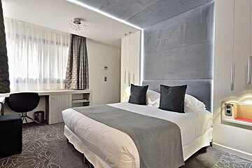 A hotel room with a bed and a desk