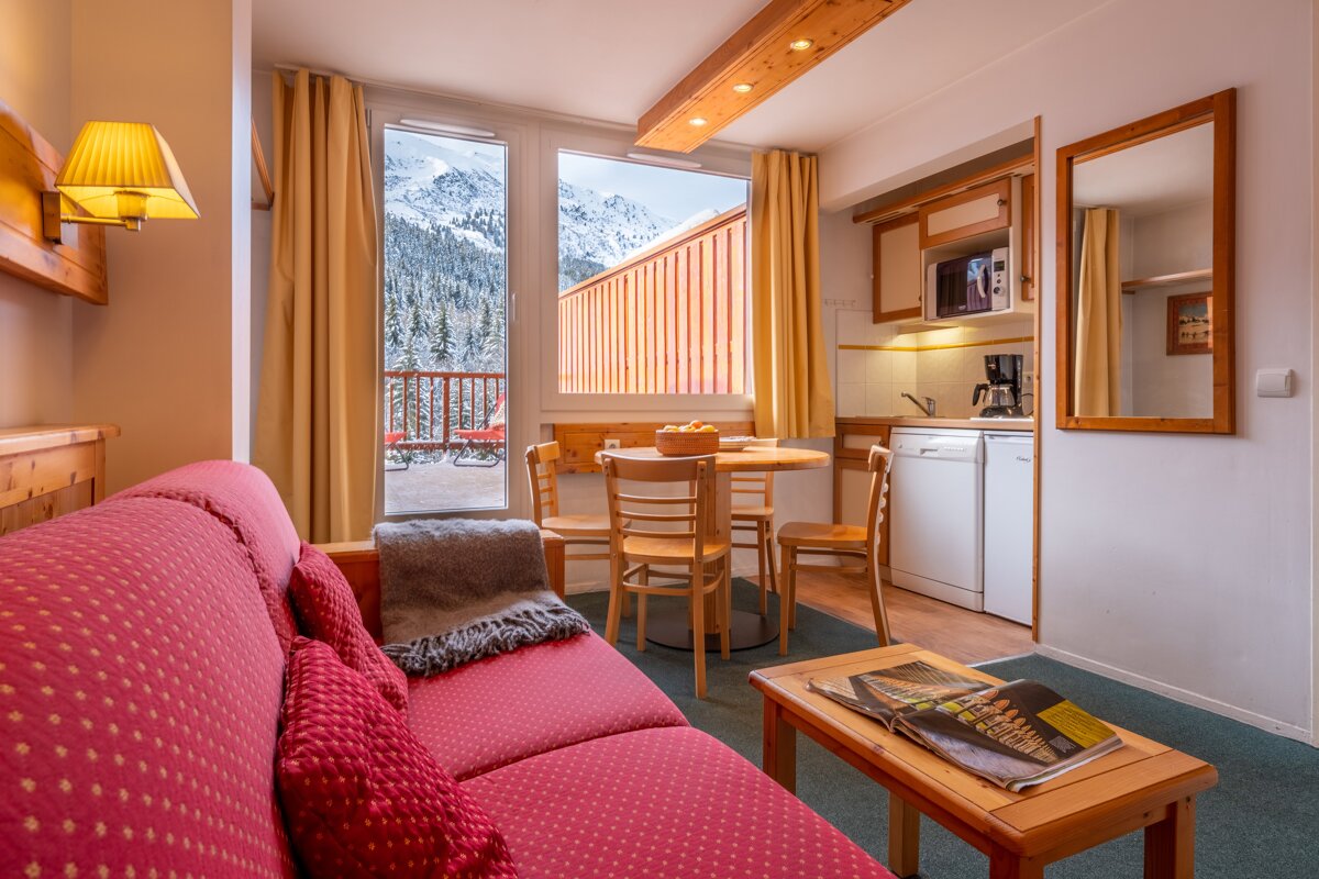 A living room with a red couch and a table