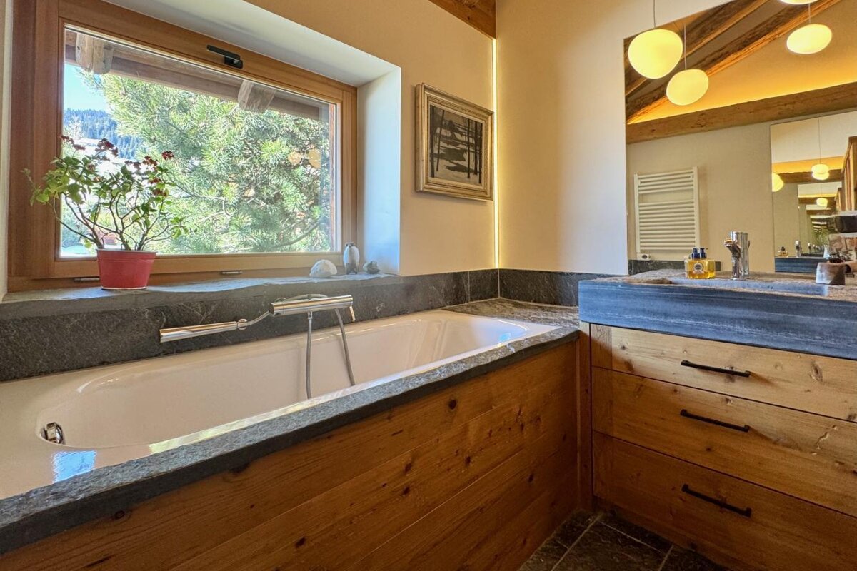 A bathroom with a tub and a sink and a window