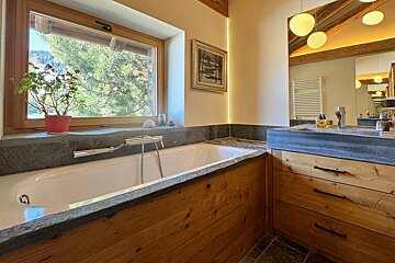 A bathroom with a tub and a sink and a window