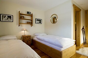 A bedroom with two beds and a mirror on the wall