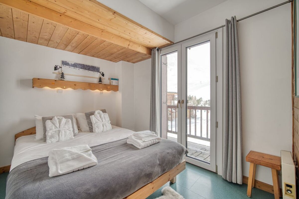 A bedroom with a king size bed and a balcony