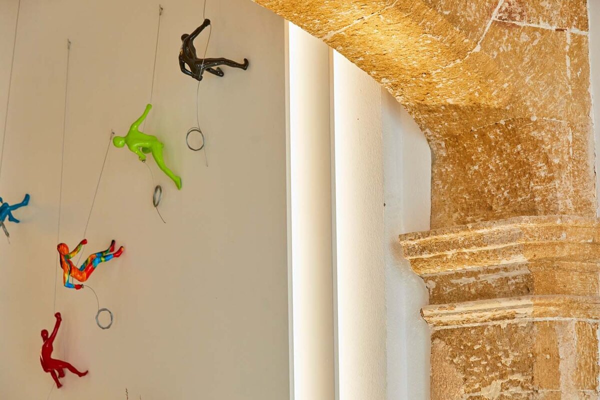 A group of colorful sculptures are hanging on a wall