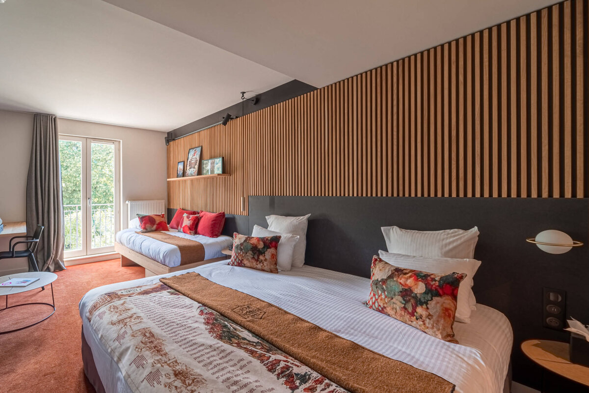 A hotel room with two beds and a table