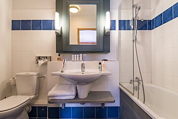 A bathroom with blue and white tiles and a sink