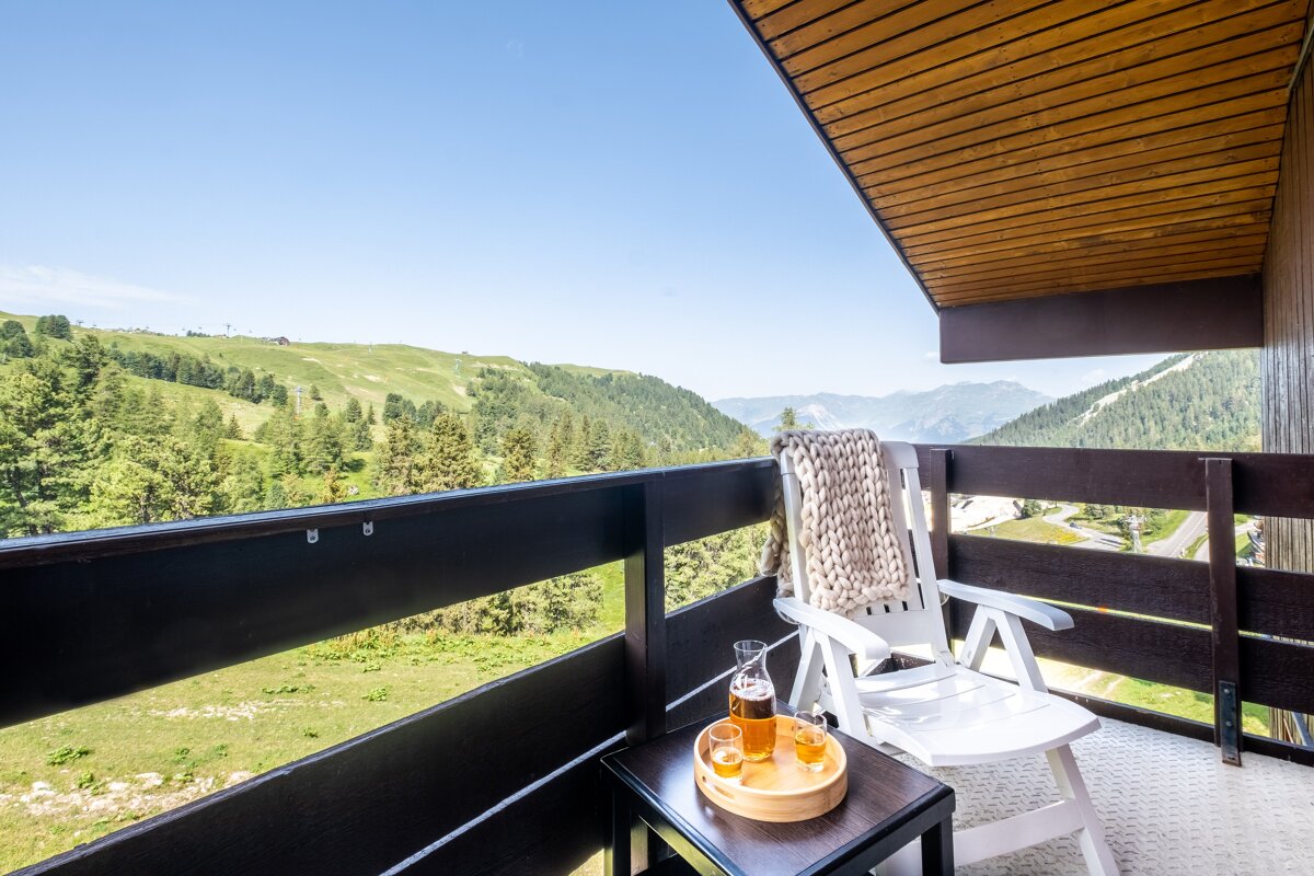 A balcony with a chair and a bottle of beer
