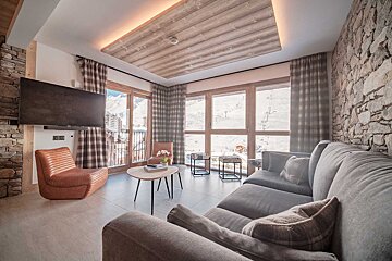 A living room with a couch a chair and a flat screen tv