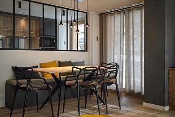 A dining room with a table and chairs and a window