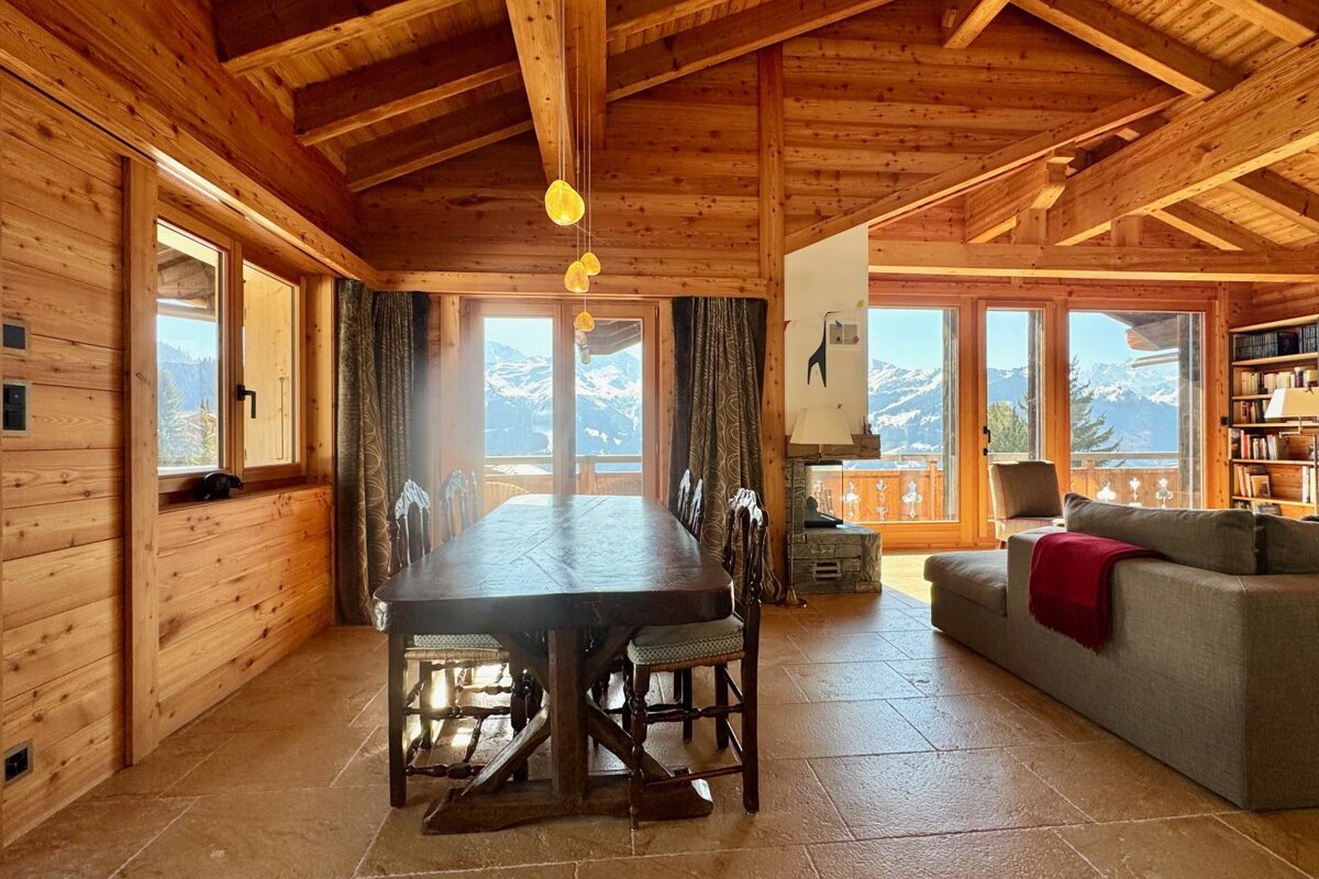 A wooden house with a dining table and chairs