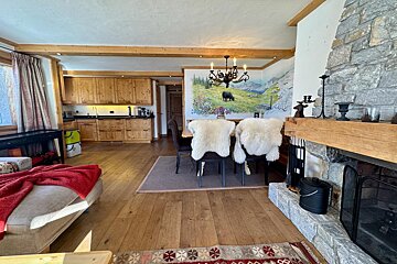 A living room with a fireplace and a painting on the wall