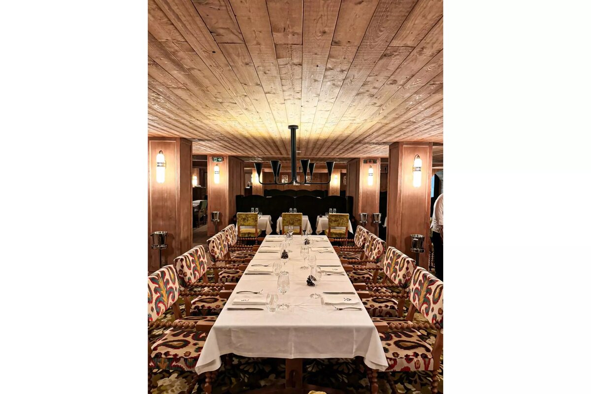 A long table in a dining room with a wooden ceiling