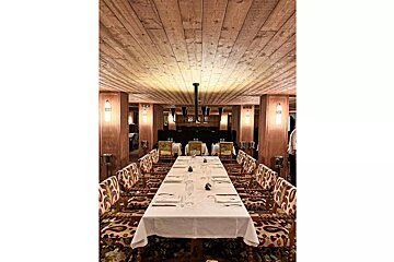 A long table in a dining room with a wooden ceiling