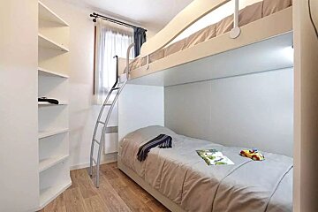 A bunk bed with a ladder and a book on it