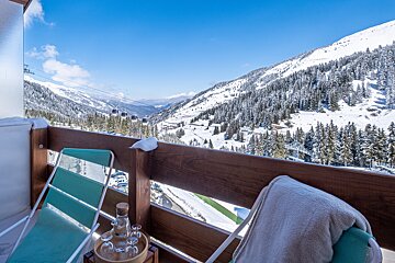 A balcony with a view of a snowy mountain range