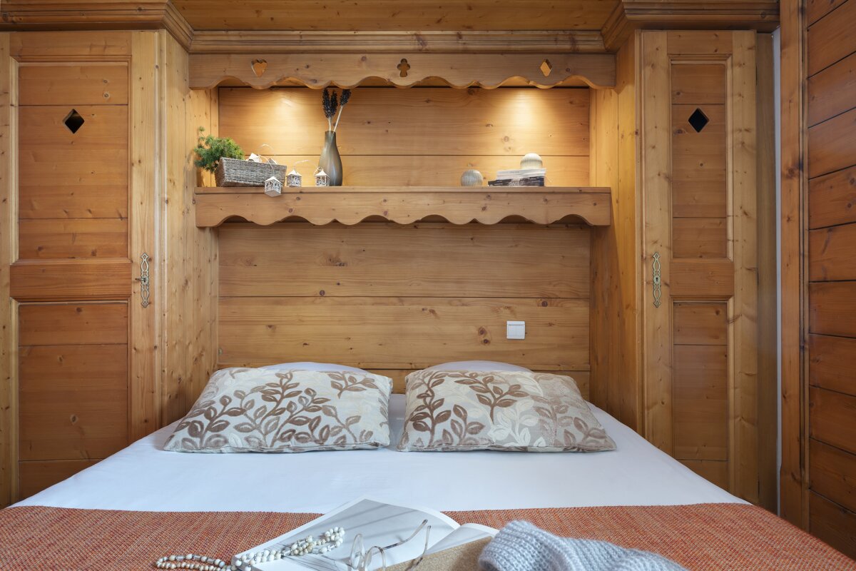 A bed with two pillows and a book on it