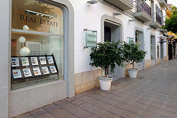 A real estate storefront with a sign that says prestige properties