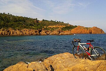 road bikes resting on the rocks near the sea in cannes