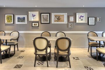 A dining room with tables and chairs and pictures on the wall