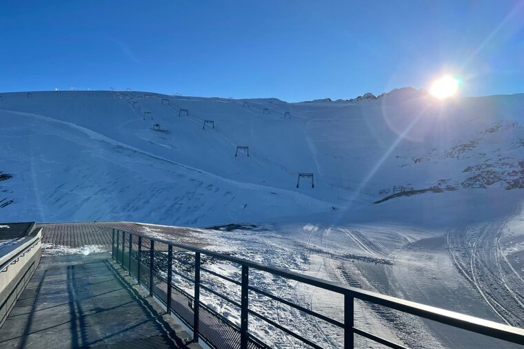 Early morning on the snowy slopes in Les 2Alpes with the sun peeping over the mountain