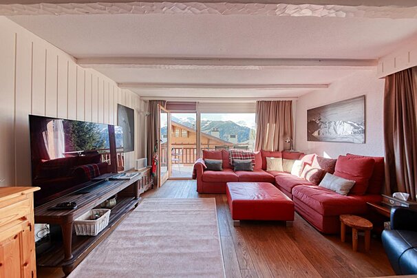 A living room with a red sectional couch and a flat screen tv