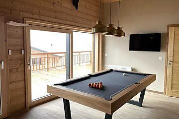 A pool table in a room with a large window
