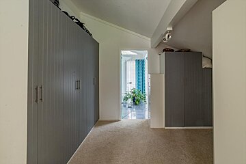 A hallway with gray cabinets and a blue curtain