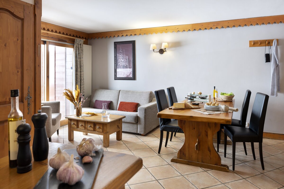 A living room with a couch a table and chairs