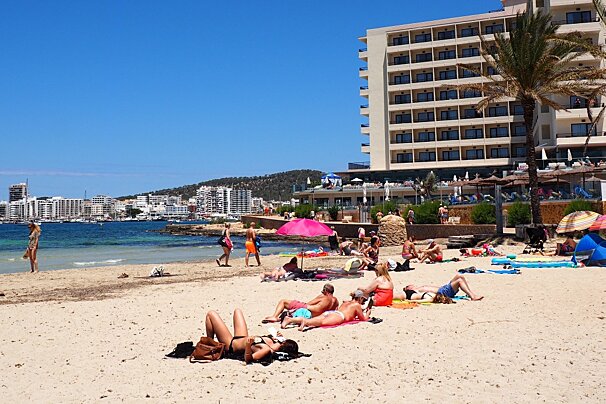 A beach in ibiza with flats behind