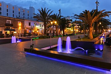 A fountain in front of a building that has the word hotel on it