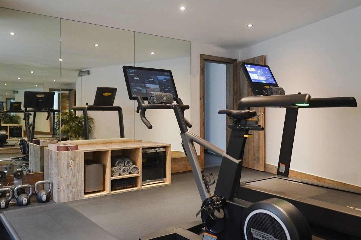 A gym with a treadmill that says technogym on it