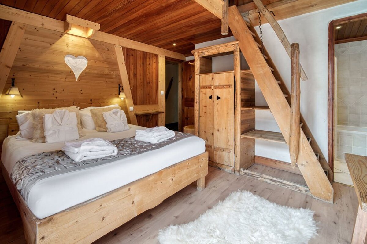 A bedroom with a wooden bed and a wooden ladder