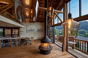 A dining room with a table and chairs and a fireplace