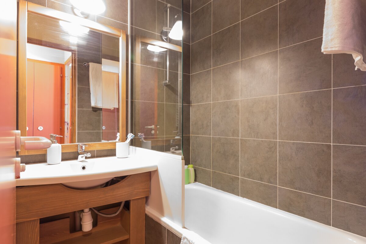 A bathroom with a sink a mirror and a bathtub