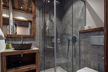 A bathroom with a sink and a walk in shower